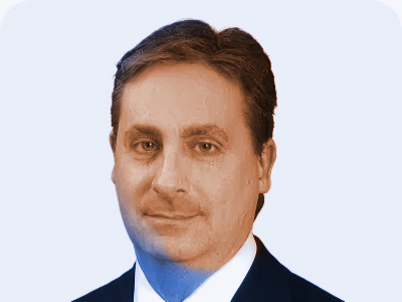 Portrait of David C. Olesen in a dark suit and tie