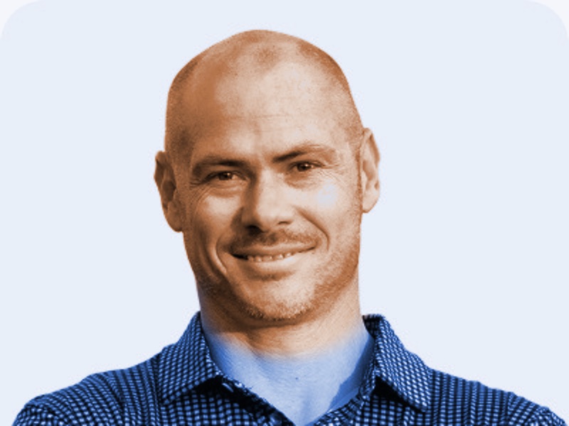 Portrait of Jack &ldquo;Matt&rdquo; Selig, smiling, in a checked collared shirt